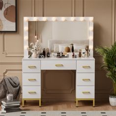 a white vanity with lights on it next to a potted plant