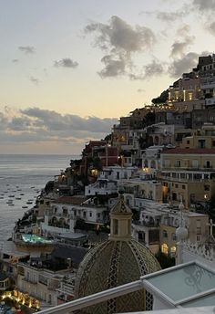 the city is lit up at night by the ocean