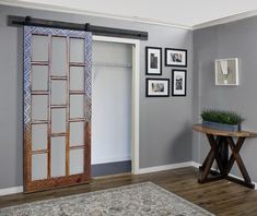 a living room with an open door and pictures on the wall next to a table