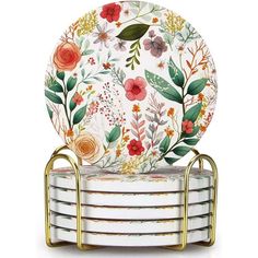 four plates stacked on top of each other with gold metal holders and floral print design