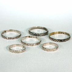 This set of 6 silver rings seems to have started life out together, so I've left them that way. I found them in the case of a wonderful woman at a fair filled with light, laughter and fabulous antiques. The rings range in size and width as follows, a size 3.25 which is 2.8 mm wide, a size 3.75 which is 2.8 mm wide, a size 9 which is 2.9 mm wide, a size 9.5 which is 3.4 mm wide, a size 10 which is 2.8 mm wide and a size 11.25 which is 2.8 mm wide. The two smallest rings are marked with a star and Vintage Wedding Toe Rings, Vintage Wedding Toe Ring Midi Rings, Vintage Stackable Jewelry With Round Band, Vintage Handmade Stackable Toe Rings, Ornate Engraved Rings For Collectors, Ornate Engraved Collectible Rings, Vintage White Gold Stamped Ring, Heirloom Style Silver Stackable Rings, Vintage White Gold Stackable Jewelry