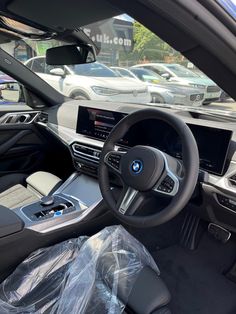 the inside of a bmw car with its dashboard and steering wheel covered in plastic wrap