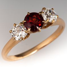 This vintage three-stone ring is centered with one (1) round natural garnet in a six-prong setting. On either side of center is one (1) old European cut diamond in a shared six -prong setting. The ring measures 6.5mm at the top, rises 5.3mm above the finger, tapering to 1.7mm wide and 1.3mm thick at the base of the shank. The ring is currently a size 7.5. The garnet has light abrasions that cannot be seen with the unaided eye. Vintage Garnet Rings, Dimond Ring, Antique Cocktail Ring, Vintage Jewelry Antique, European Cut Diamonds, Three Stone Rings, Garnet Rings, Three Stone, Stone Ring