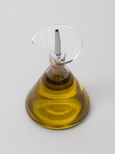 a yellow glass vase with a small white object in the middle of it's top