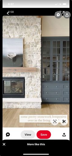 a living room filled with furniture and a fire place in front of a stone wall