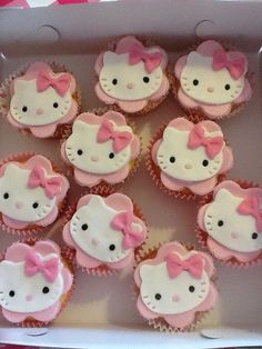 hello kitty cupcakes are in a box with pink and white frosting on them