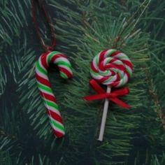 two candy canes are hanging from a christmas tree ornament, one is green and the other is red