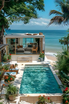 an outdoor swimming pool surrounded by greenery next to the beach with chairs and tables