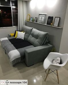 a living room with a gray couch and white chair in front of a large window