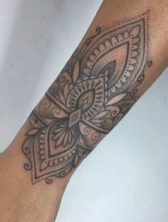 a woman's arm with a tattoo on it and an intricate design in the middle