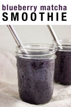 two mason jars filled with blueberry matcha smoothie on top of a white cloth