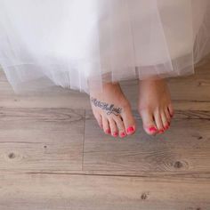 a bride's feet with tattoos on their toes