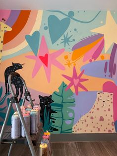 a ladder is in front of a colorful wall mural