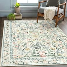 a white rug with an ornate design on the floor next to a chair and potted plant