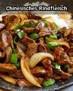 a close up of a plate of food with meat and onions on it in chinese