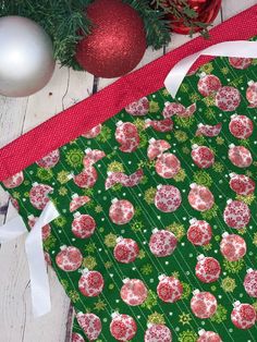 a green wrapping paper with red and white ornaments on it