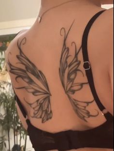 the back of a woman's bra with butterfly tattoos on her upper and lower back