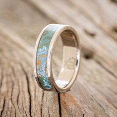 a wedding ring that has been painted with blue and gold paint on the inside of it