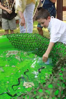 a young boy is playing in a fake pond made out of plastic bottles and leaves