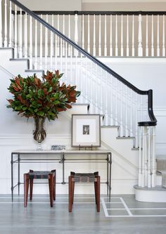 an image of a staircase and table with flowers on the top, in front of it