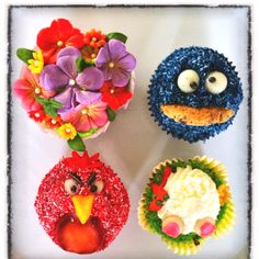 four cupcakes decorated to look like angry birds and flowers with eyes on them