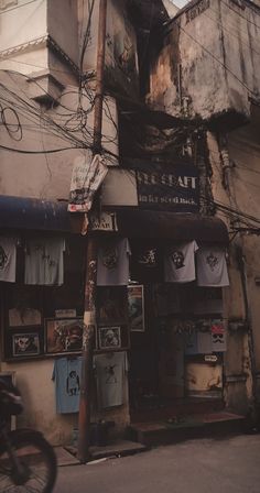 an old building with clothes hanging from it's sides and a bicycle parked in front