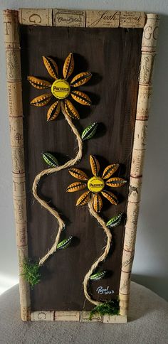 an art piece made out of wine corks with flowers on the top and bottom