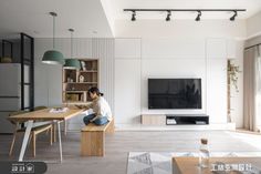 a living room filled with furniture and a flat screen tv on top of a wooden table