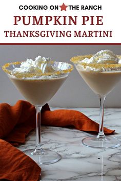 pumpkin pie martinis with whipped cream and orange garnish in coupe glasses on a marble countertop