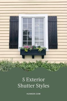 a window with black shutters and flowers in the window box below it is an image of