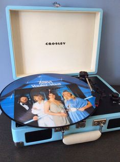 an old record player with two women on it sitting in a blue case that is open