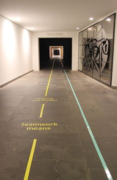 an empty parking garage with yellow lines painted on the floor and graffiti on the walls