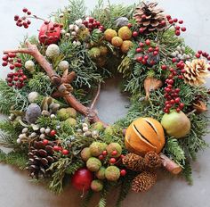 a christmas wreath with pine cones and other decorations