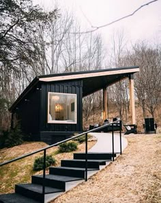 a black cabin with stairs leading up to it