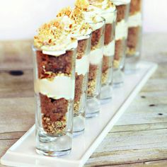 small desserts are lined up on a white tray and ready to be served in individual cups