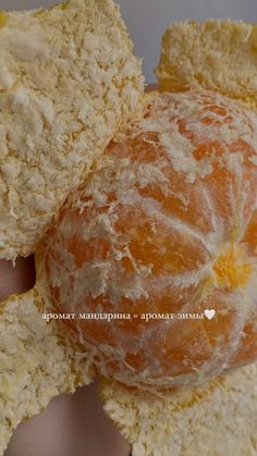 an orange is being held in the palm of someone's hand with some bread on it