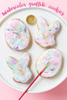 three decorated cookies sitting on top of a white plate