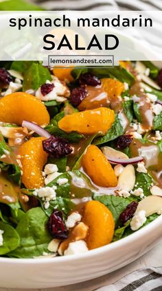 spinach salad with oranges, almonds and feta cheese in a white bowl