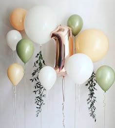 balloons and greenery are hanging from the wall