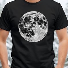 a man wearing a black t - shirt with the moon on it's chest