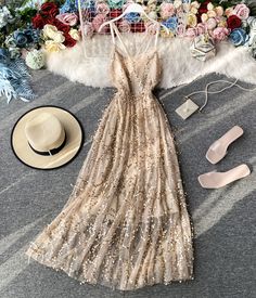 Step into the spotlight with this elegant gold sequin spaghetti strap maxi dress, perfect for making a dazzling entrance at any special event. The dress features a delicate nude tulle overlay adorned with shimmering gold sequins that catch the light with every movement, creating a radiant and glamorous effect. The slim spaghetti straps and V-neckline highlight your shoulders and collarbone, adding a touch of femininity and allure to the overall design.The flowing A-line silhouette flatters a var Prom Season Sequin Dress With Spaghetti Straps, Sequin Spaghetti Strap Dress For Prom, Gold Embellished Dress With Spaghetti Straps, Beige Spaghetti Strap Dress For Party, Spaghetti Strap Maxi Dress For Wedding Guest And Prom, Embellished Spaghetti Strap Sequin Wedding Dress, Summer Tulle Maxi Dress With V-neck, Gold V-neck Evening Dress For Summer, Chic Gold Maxi Dress With Spaghetti Straps