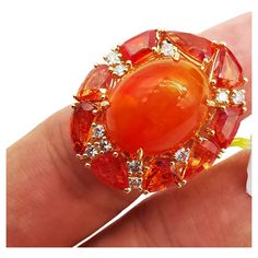 The Following Item we are offering is a Rare Important Radiant 18KT Gold Large Fancy Fiery Orange Opal Diamond Orange Sapphire Ring. Ring is comprised of A LARGE Gorgeous Fancy Fiery Orange Opal surrounded by a Beautiful Halo of Fancy Orange Sapphires and Diamonds!! T.C.W APPROX 14.50CTS!!! Comes with New with Tags from a Private Manufacturer that sells to Important 5 Star Hotel and Fine Jewelry Stores. Original Retail Price: $9,209.00!!! A Gorgeous Masterpiece!!! Luxury Cluster Ring Gift, Yellow Gold Multi-stone Rings For Party, Luxury Gold Cluster Ring With Accent Stones, Luxury Cluster Ruby Ring Gift, Luxury Ruby Ring For Party, Luxury High Luster Gemstones For Formal Occasions, Elegant Round Orange Gemstones, Luxury Yellow Gold Cluster Ring With Accent Stones, Luxury Cluster Ring In Yellow Gold With Accent Stones