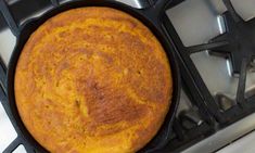 a cake in a pan sitting on top of an oven burner with the lid open