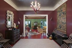 a living room filled with furniture and a chandelier hanging from the ceiling above it