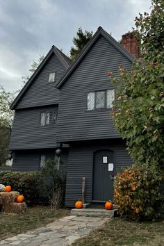 a black house with pumpkins in front of it