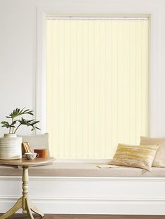 a white window with yellow blinds and pillows