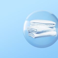 three folded white sheets sitting on top of each other in front of a blue background