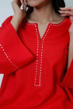 a woman wearing a red top with white stitching