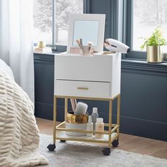 a white and gold vanity with mirror, hairdryer, and other items on it