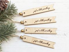 three wooden bookmarks with the words, just a little something and an ornament